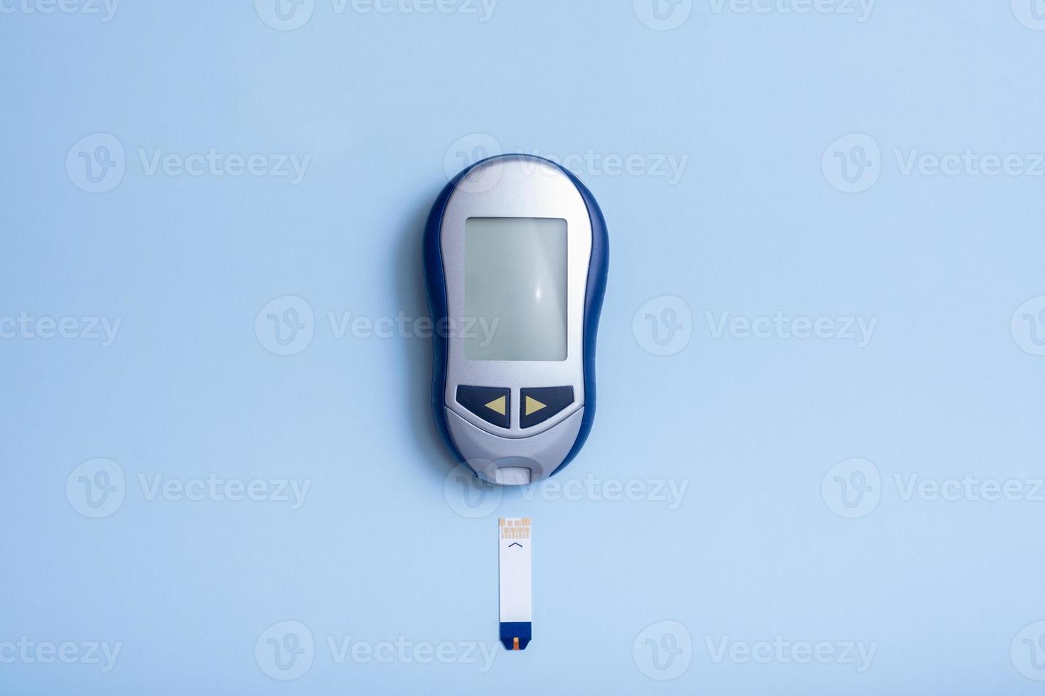 top vie medidor de glicose em um fundo azul. conceito de teste de diabetes foto