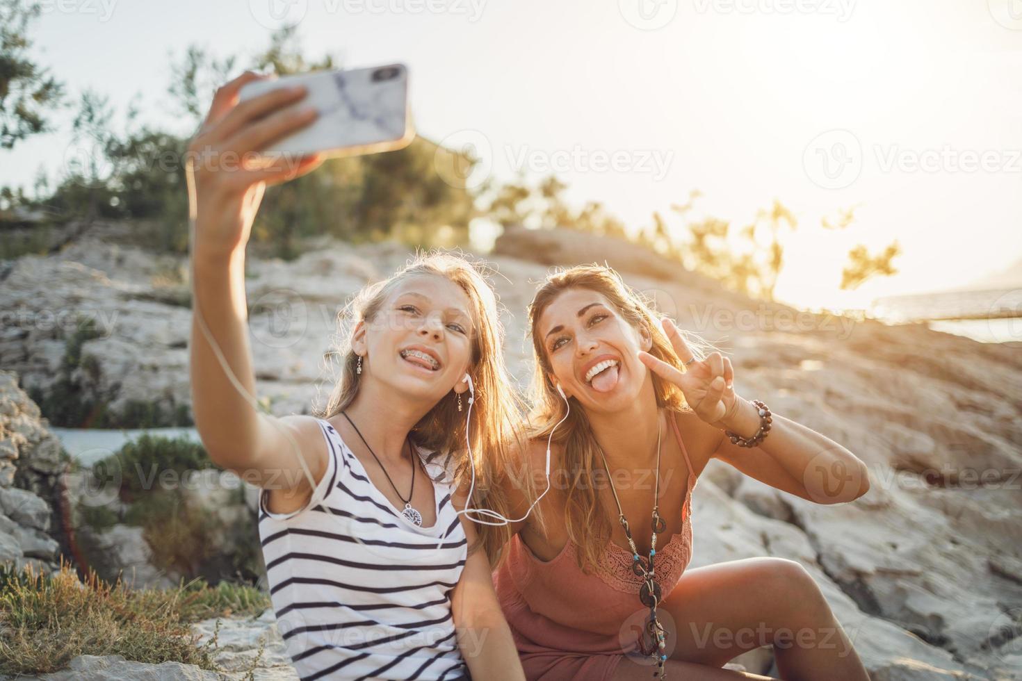 duas amigas se divertindo enquanto tirava uma selfie nas férias de verão foto