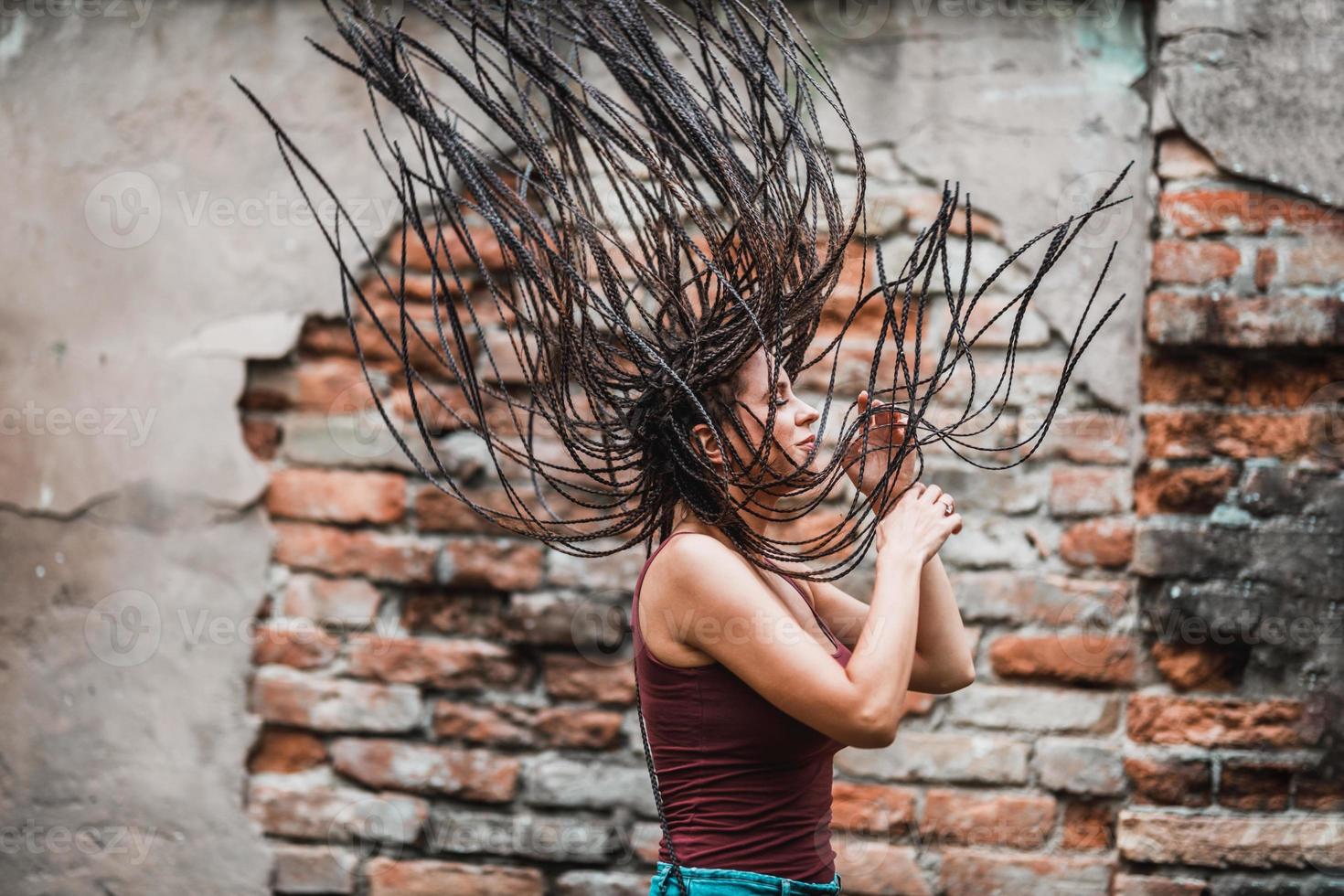 mulher com longos cabelos trançados afro se divertindo ao ar livre foto