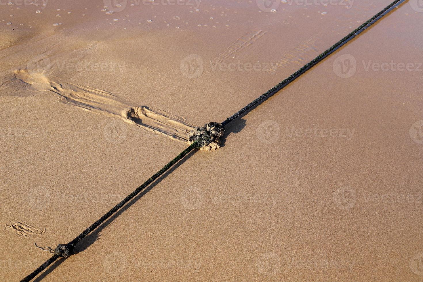 corda de cânhamo com bóias na praia da cidade foto