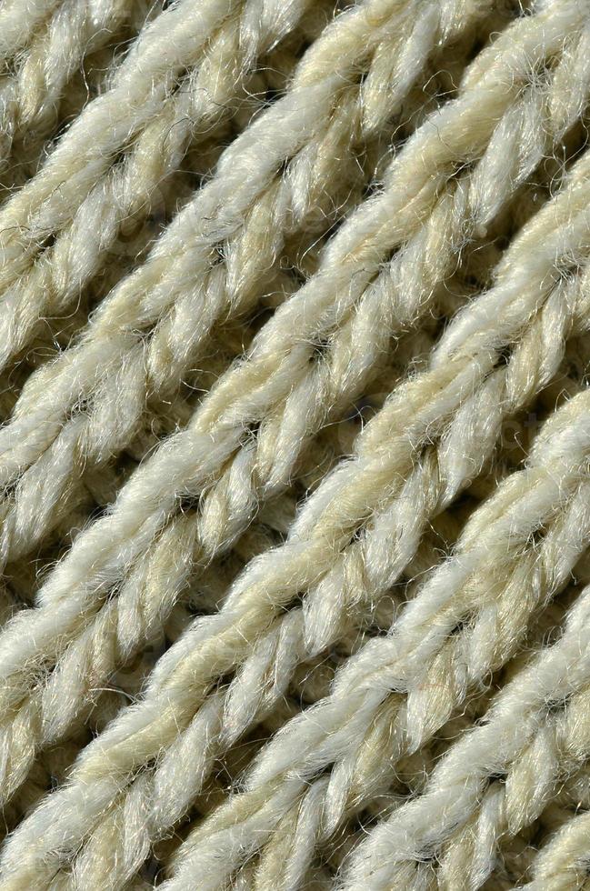 textura de tecido de um suéter de malha amarelo macio. imagem macro da estrutura de ligações em fios foto
