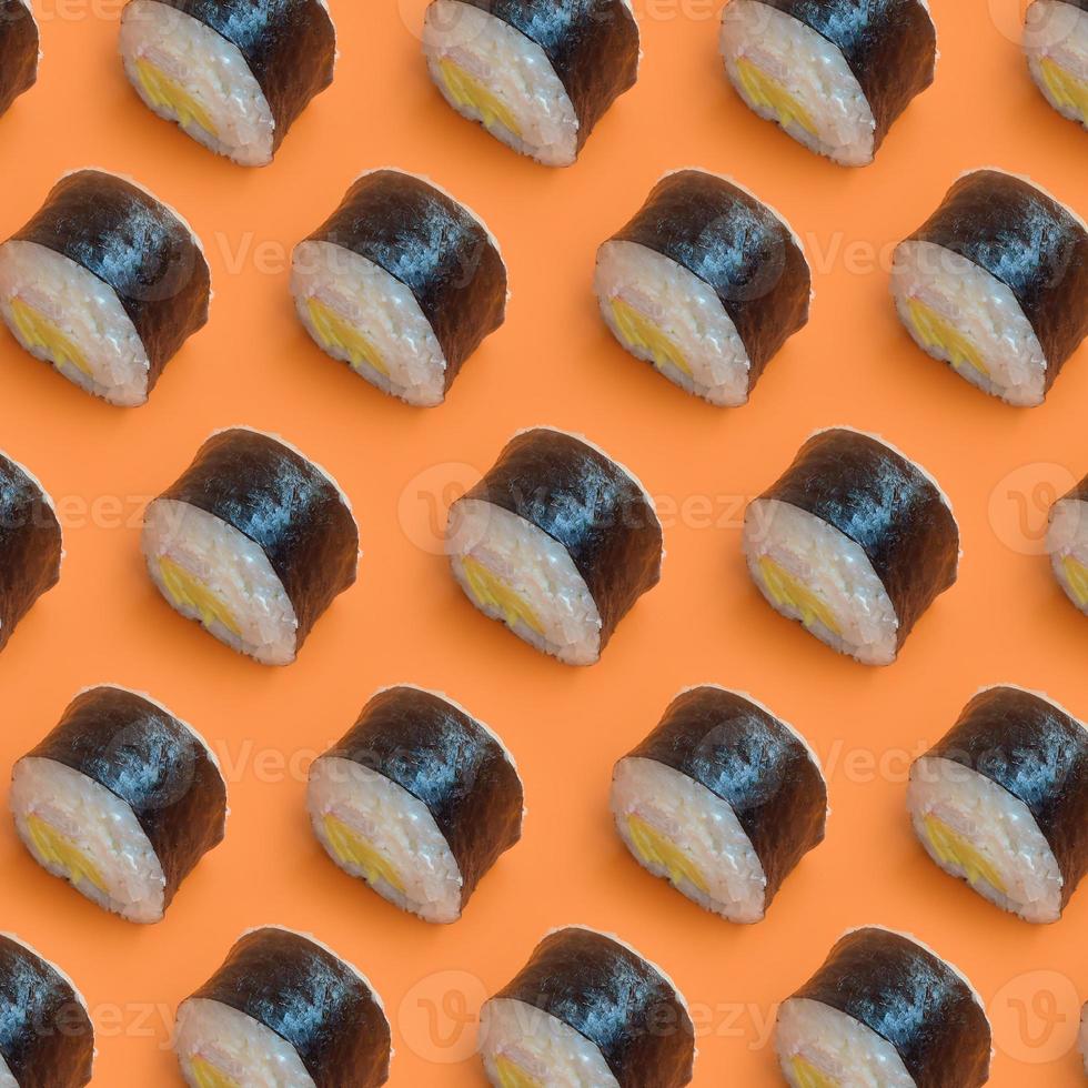 rolos de sushi preto clássico em fundo laranja brilhante foto