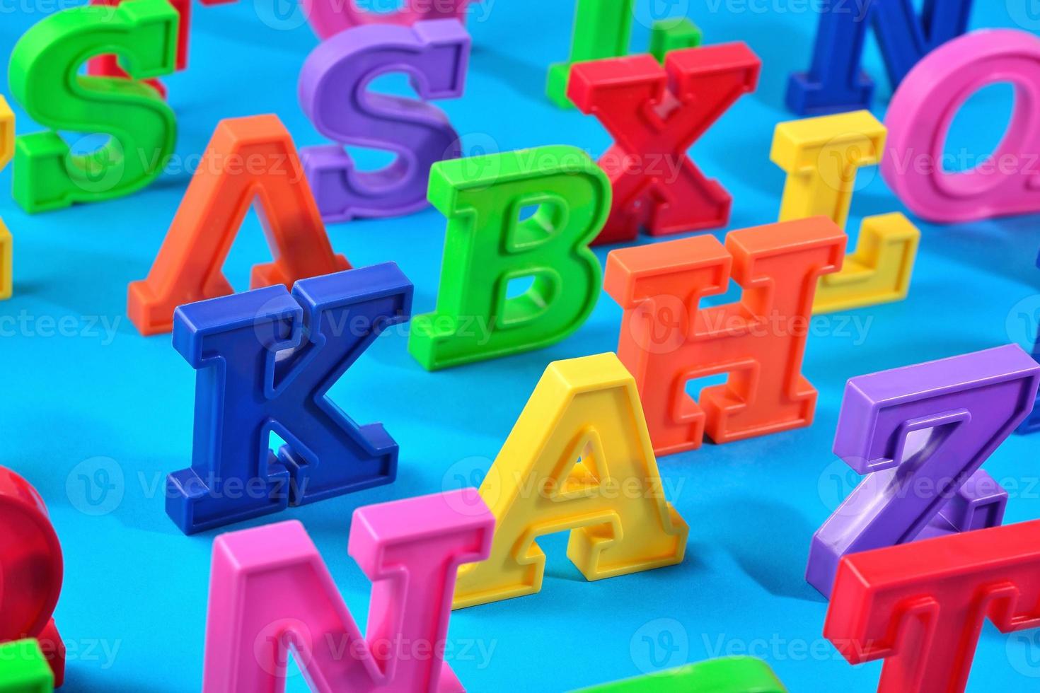 letras coloridas de plástico do alfabeto em um fundo azul foto