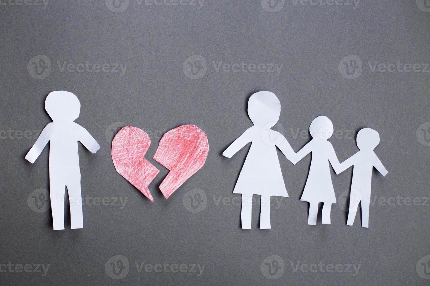 corrente de papel corta família com coração partido em fundo cinza. divórcio e conceito de família quebrado foto