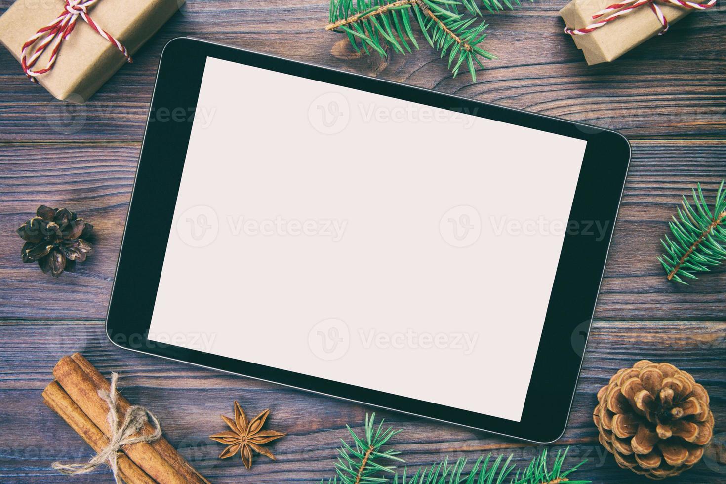 tablet digital simulado com decorações rústicas de fundo de madeira de natal para apresentação de aplicativos. vista superior vintage, em tons com espaço de cópia foto