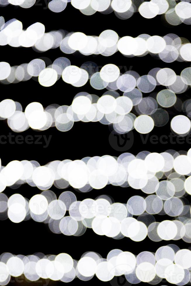 bokeh luzes brancas sobre fundo preto. abstrato desfocado muitas luzes redondas foto