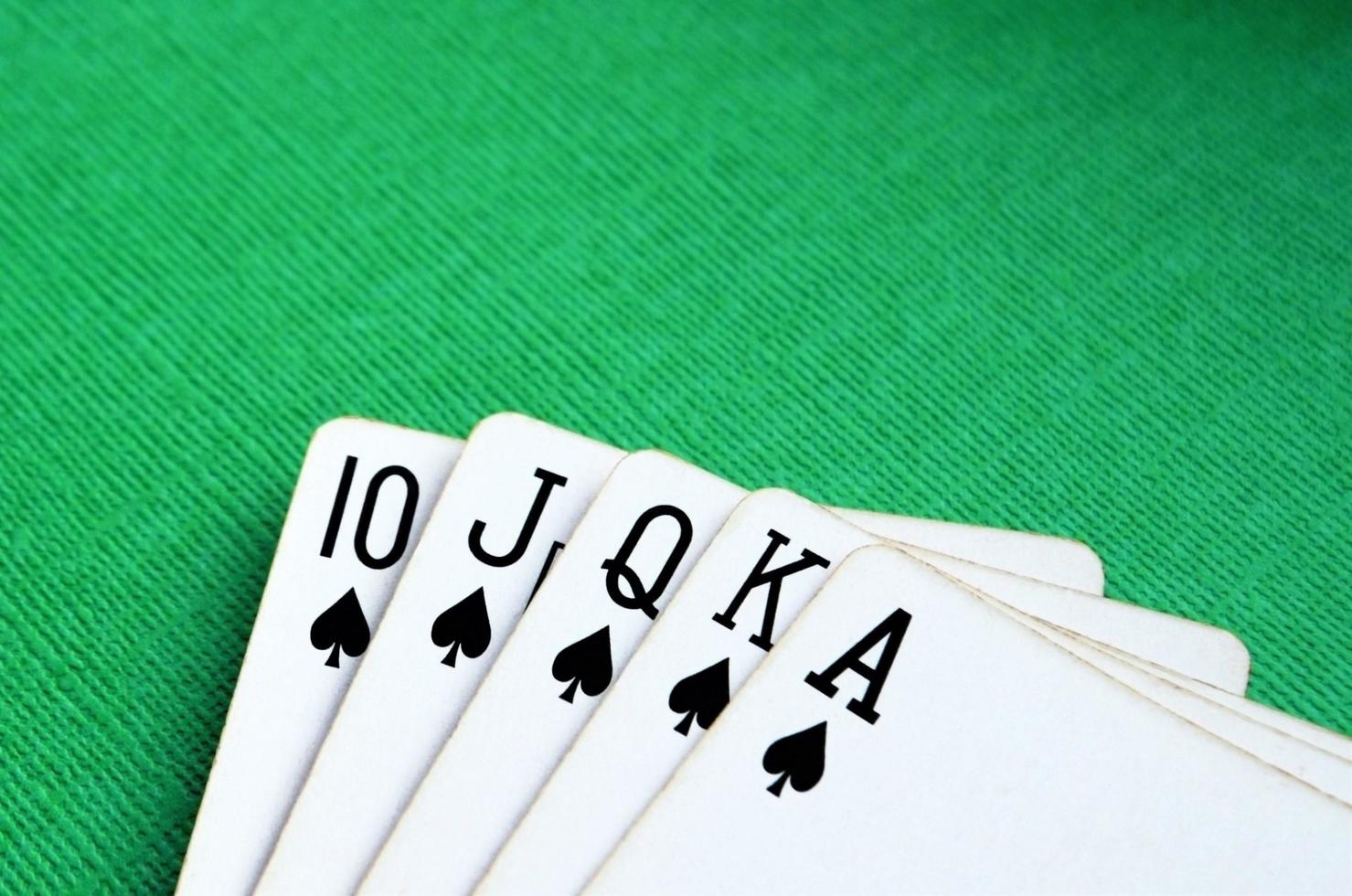 velhas cartas de baralho em um fundo verde. combinação de cartas royal flush. copie o espaço para o texto. conceito de jogo. cartas de pôquer. foto