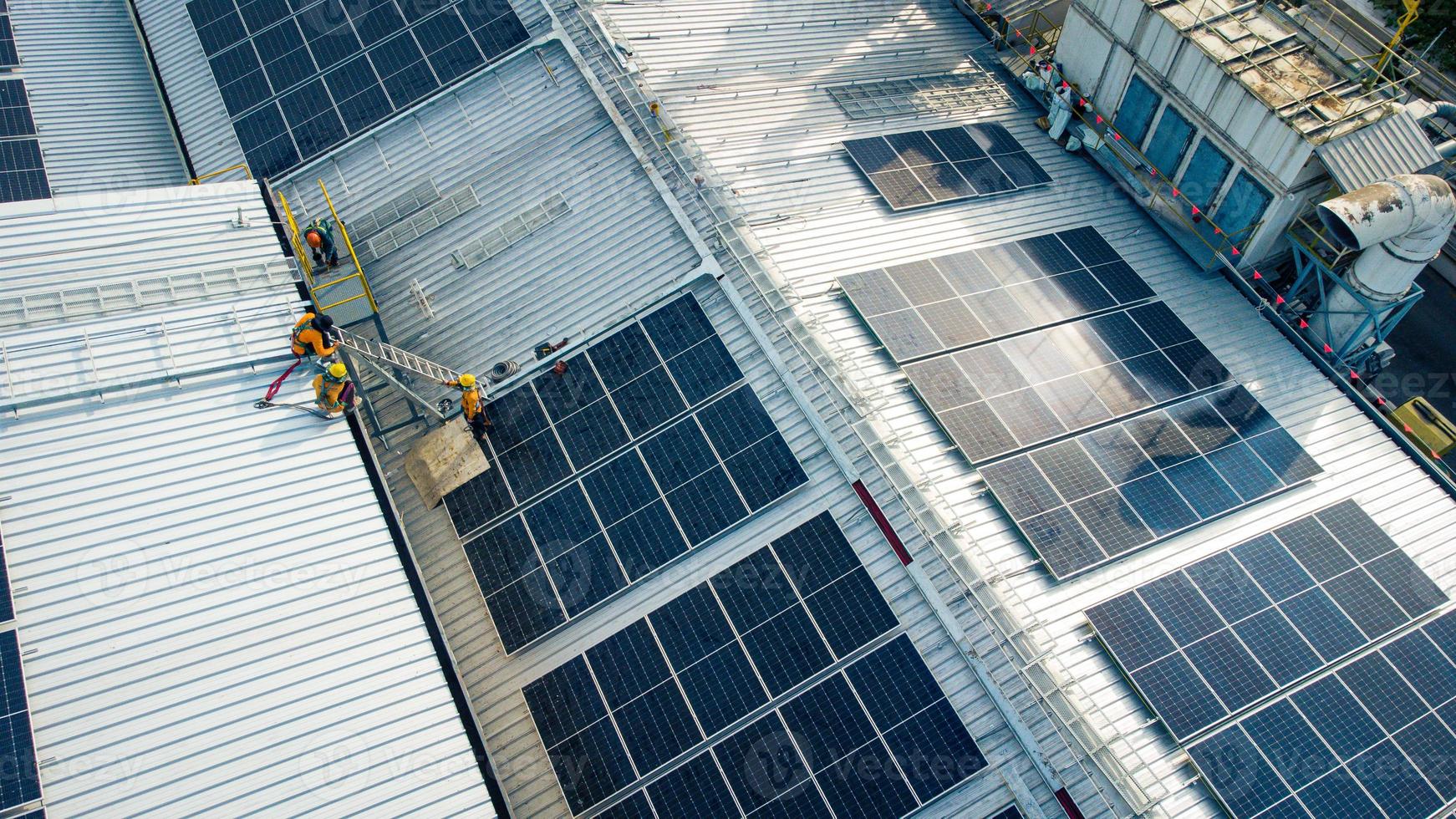 sobrevoar engenharia não identificada montar uma célula solar no telhado de uma grande fábrica industrial. os telhados solares estão gerando energia renovável para a indústria. foto