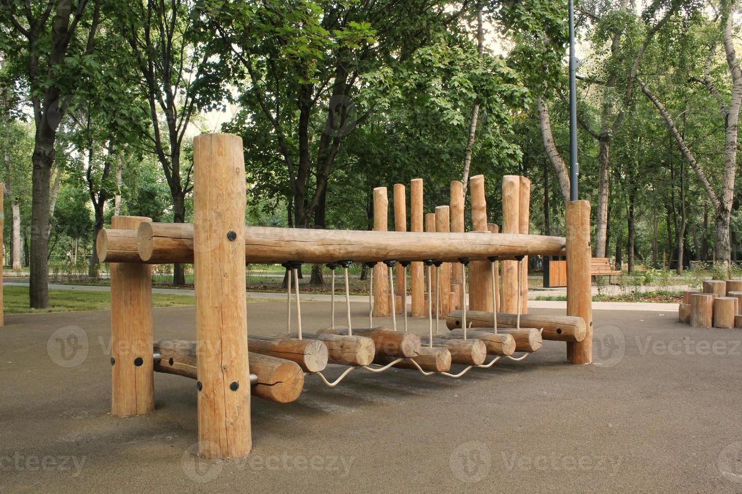ponte de corda no playground de madeira de crianças modernas ao ar livre em um parque público da cidade. descanso de estilo de vida ecologicamente correto e conceito infantil de infraestrutura ambiental de segurança para crianças. aventura engraçada foto