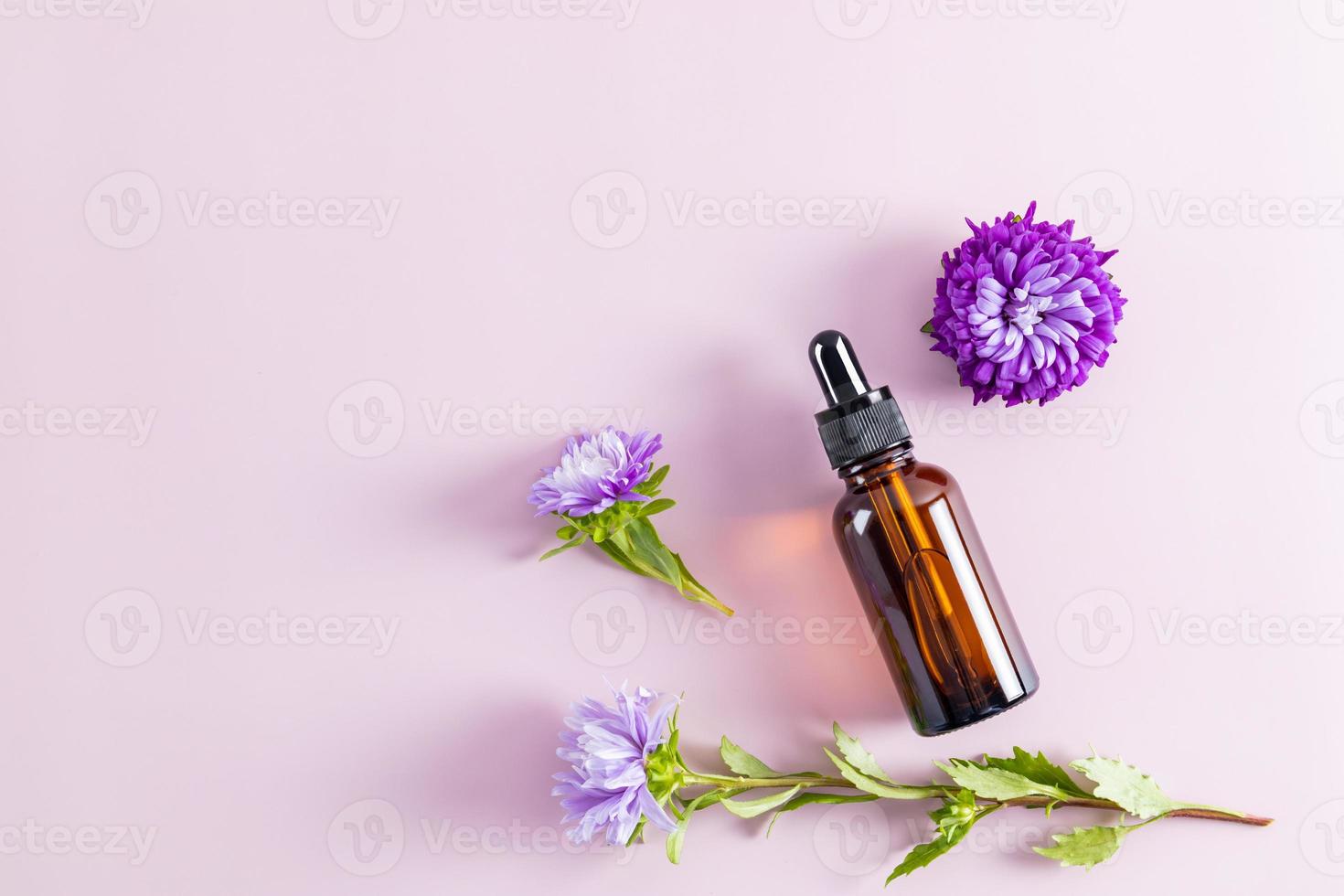 uma garrafa com um conta-gotas em um fundo pastel com flores de outono. cosméticos ativos exclusivos. preservação da pele jovem. vista do topo. um espaço de cópia. foto