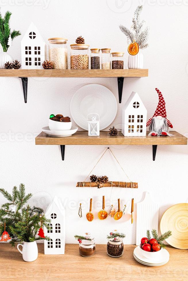 decorando uma cozinha de casa para o ano novo decorada com artesanato com as próprias mãos. casas de papelão, guirlandas de laranjas secas e canela. foto