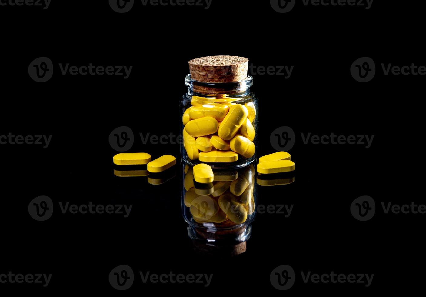 pílulas laranja brancas em copo de vinho. em jarra. no balde isolado no conjunto preto de cápsula e comprimidos dentro de closeup, foto