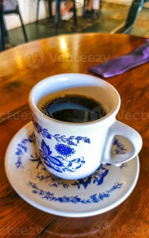 pote de xícara branca azul com mesa de madeira de café preto méxico. foto