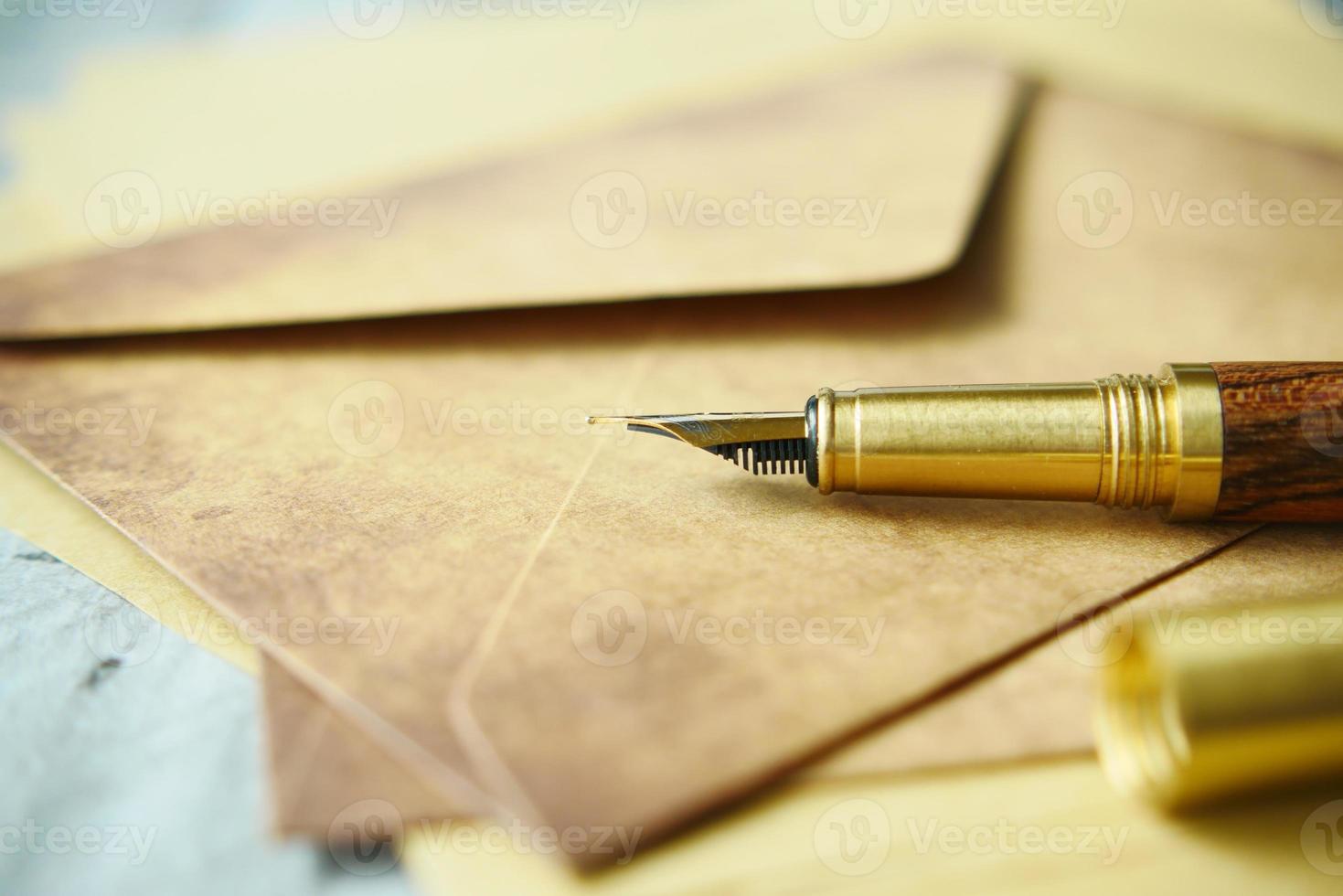 envelope, papel vazio e caneta-tinteiro na mesa foto
