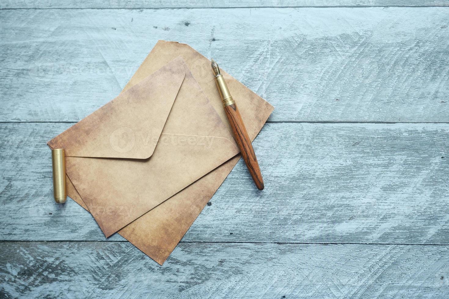 envelope, papel vazio e caneta-tinteiro na mesa foto