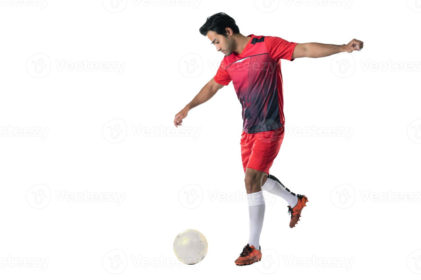 jogador de futebol profissional em pose de uniforme de treinamento vermelho em um conceito de futebol de fundo branco ativo. foto