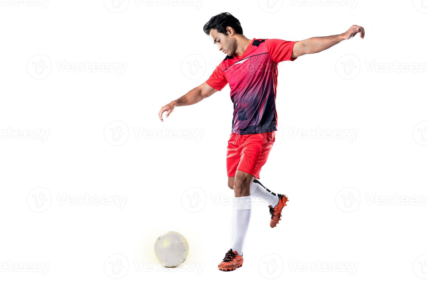 jogador de futebol profissional em pose de uniforme de treinamento vermelho em um conceito de futebol de fundo branco ativo. foto