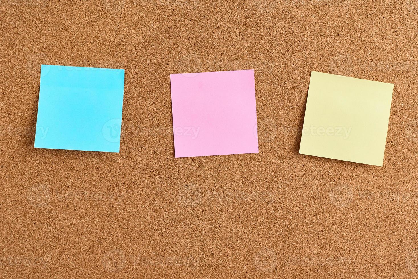 placa de cortiça com notas em branco de papel colorido, close-up foto