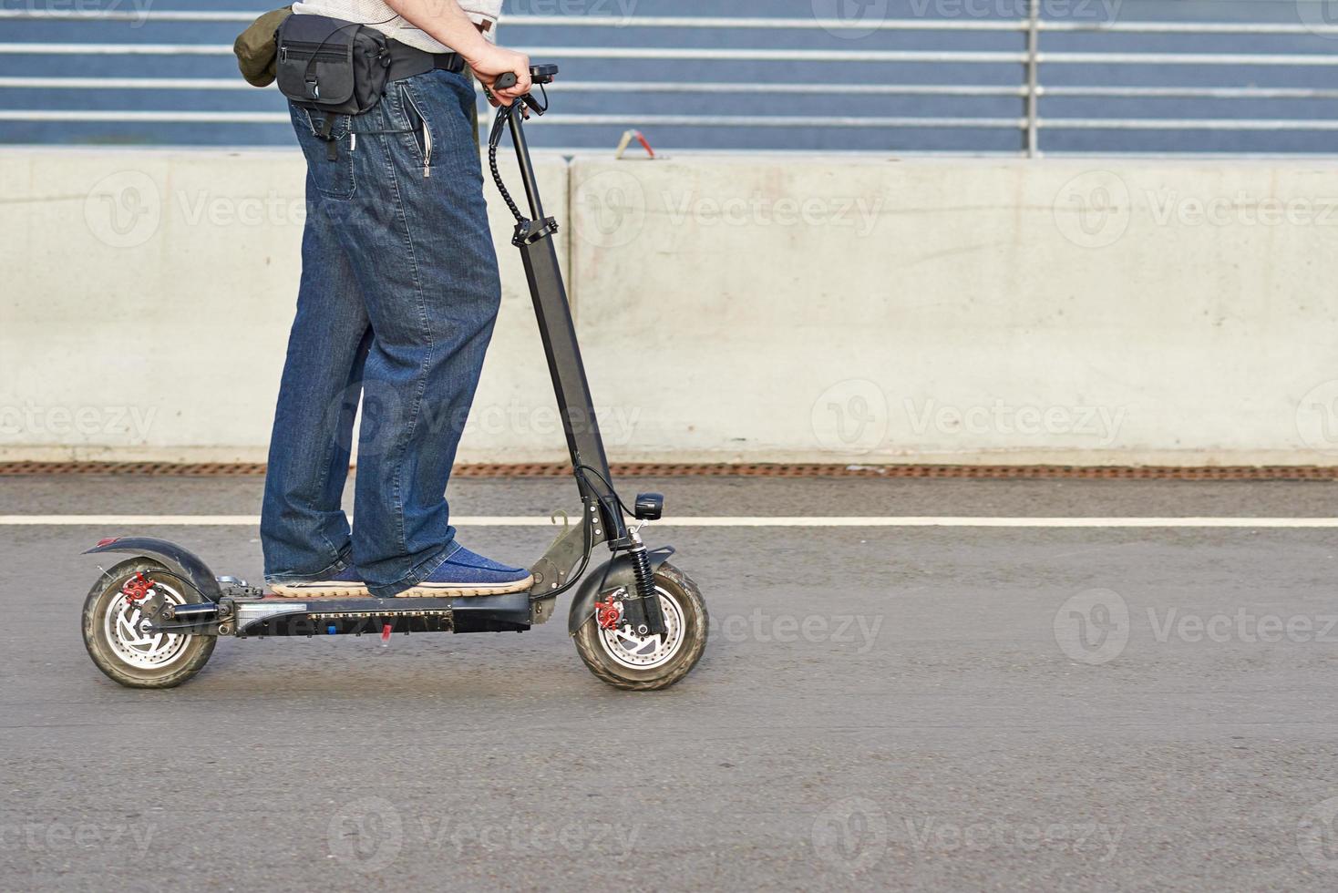 close-up do homem dirigindo na scooter elétrica na cidade foto