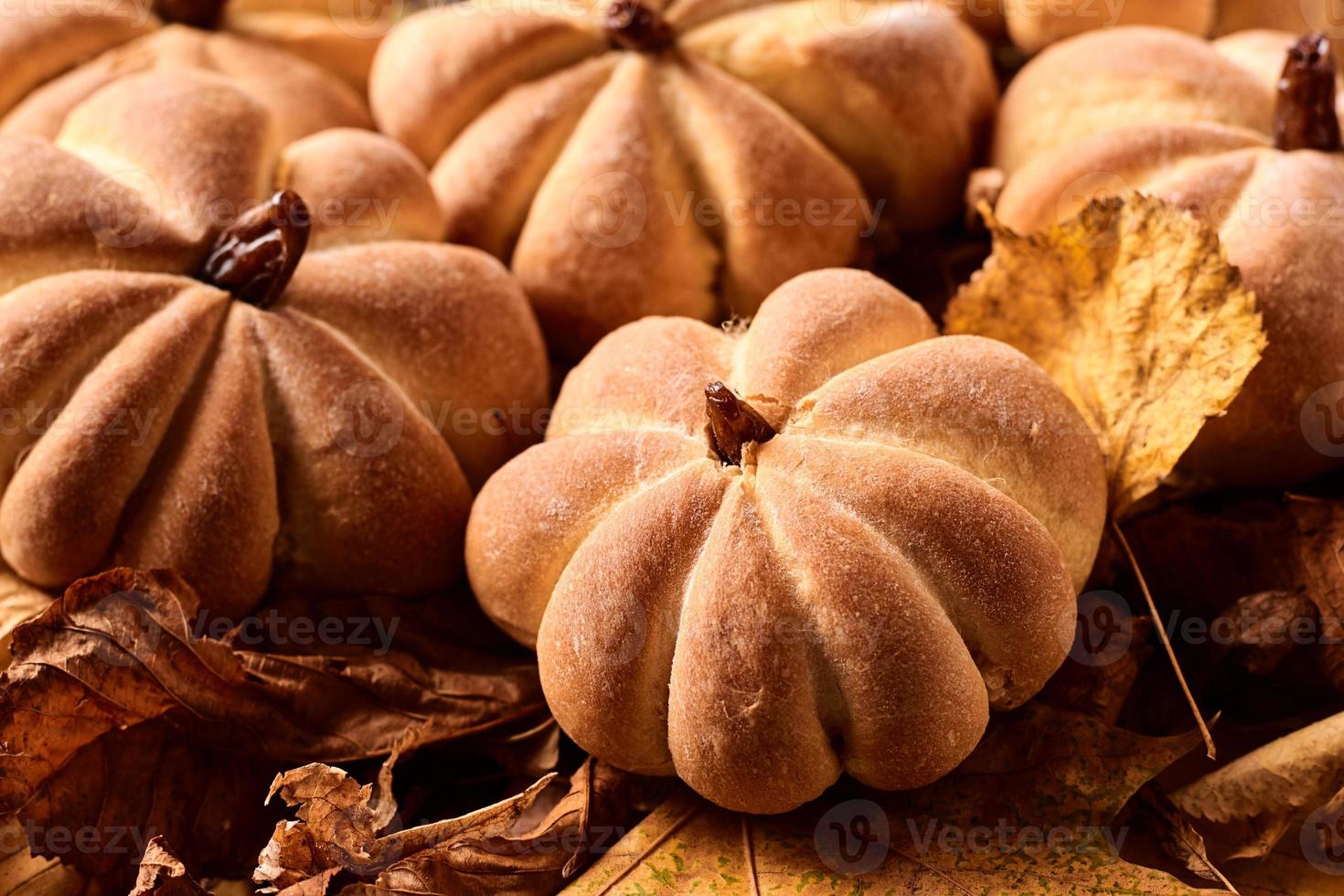 biscoitos caseiros em forma de abóbora em folhas de outono. foto