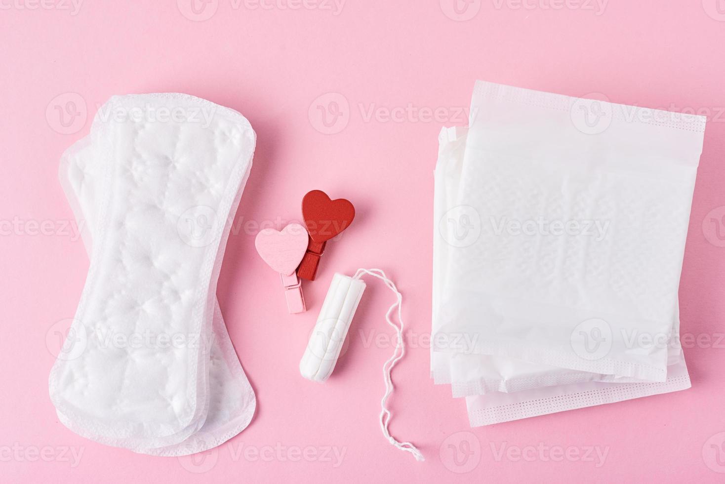 absorvente higiênico, tampão menstrual e coração vermelho de madeira foto