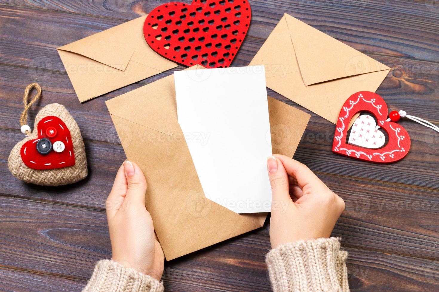 garota segurando um envelope com corações de dia dos namorados. conceito de dia dos namorados com copyspace foto