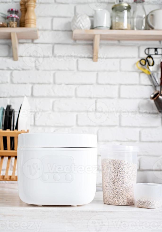 panela de arroz elétrica na bancada de madeira na cozinha foto