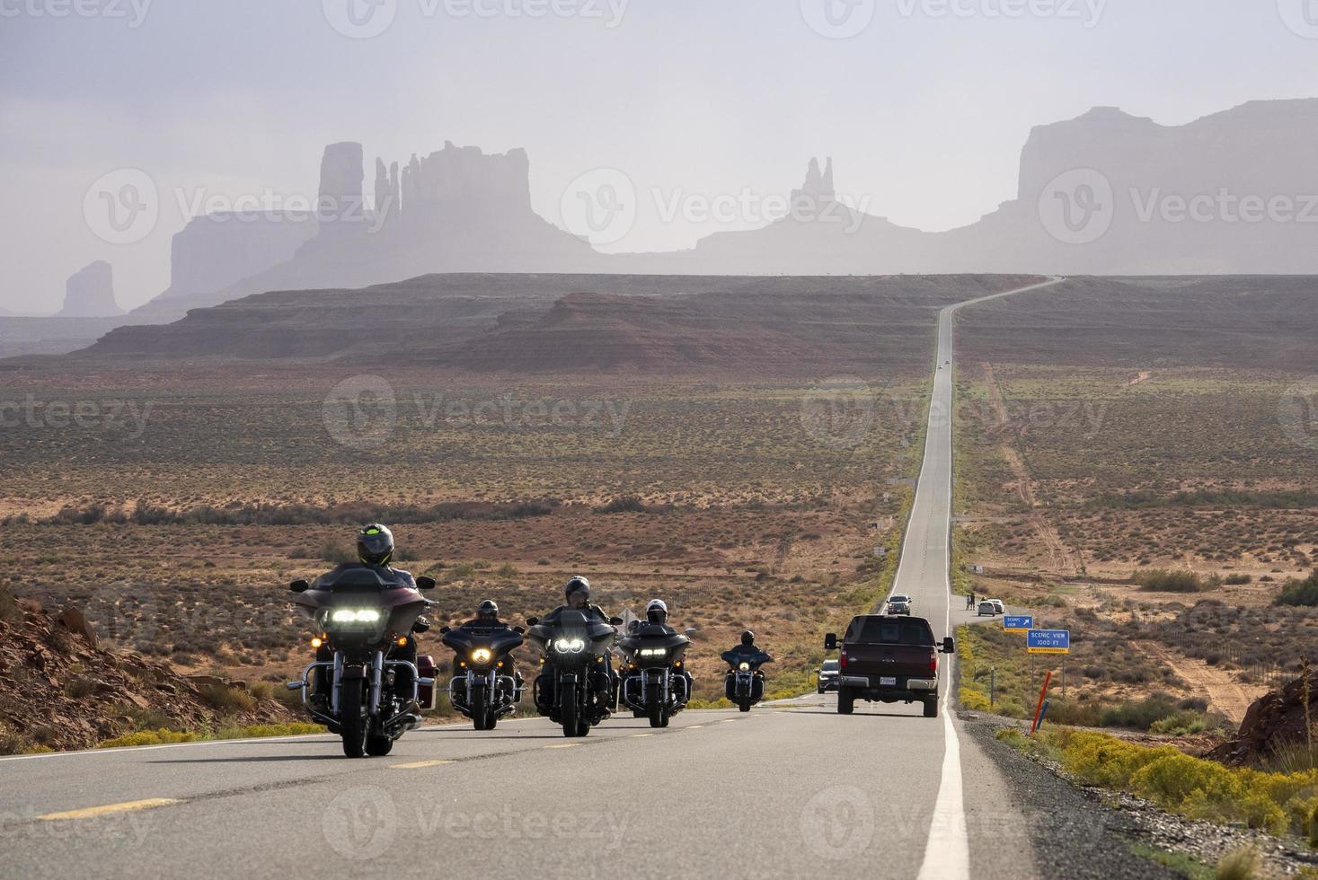turistas andando de moto na estrada no parque monument valley no verão foto