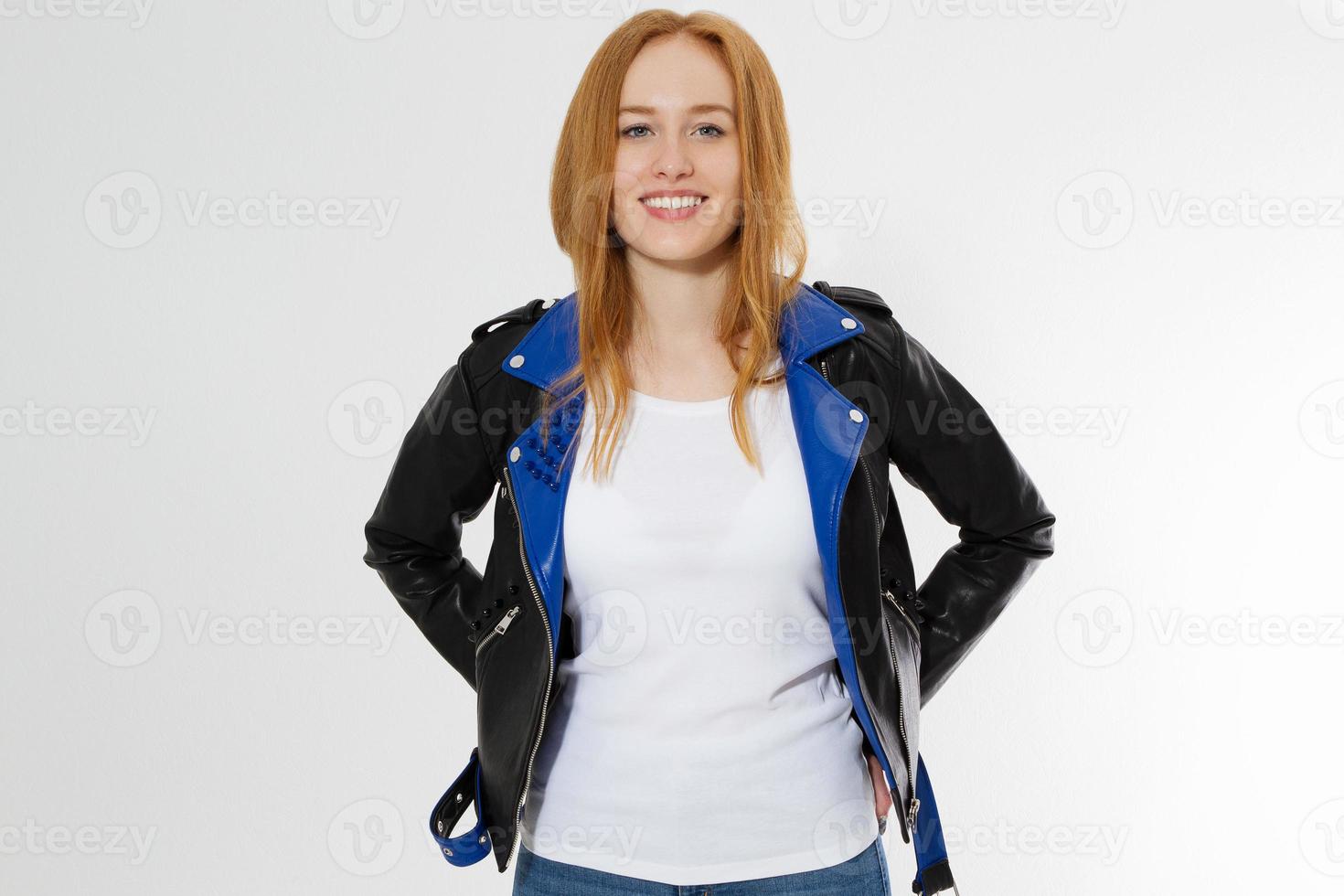 feliz animado jovem na camiseta branca e jaqueta de couro preta, isolada no fundo branco. garota de cabelo vermelho na vista frontal de roupas de moda. camiseta de verão modelo em branco. espaço de cópia foto