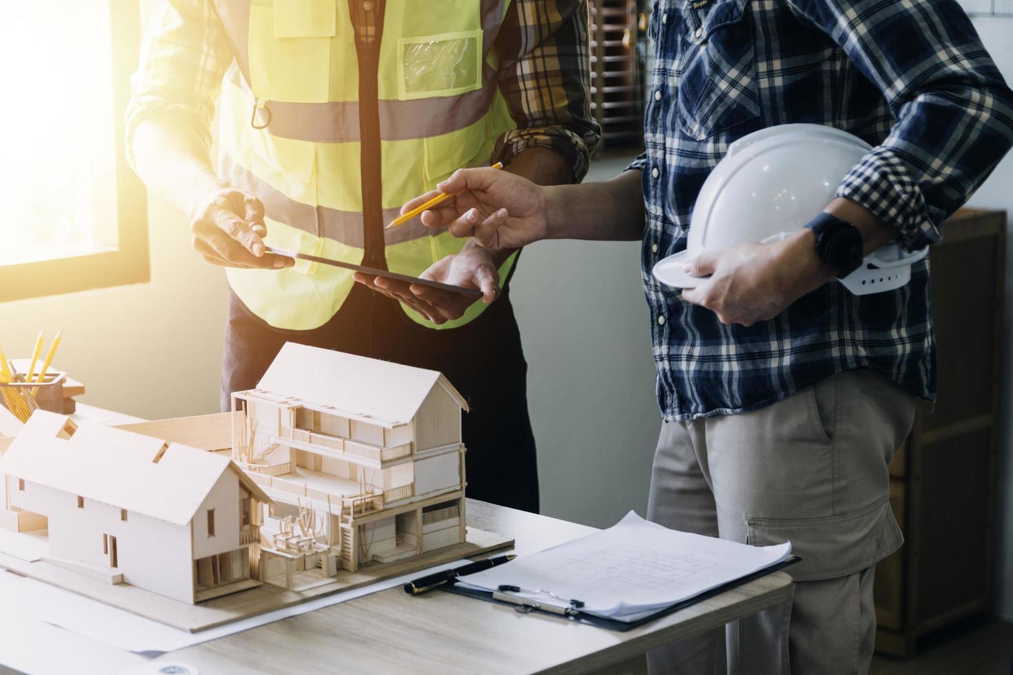 engenheiro de construção trabalhando na planta para construir grandes edifícios comerciais no escritório. ferramentas de engenharia e conceito de construção. foto