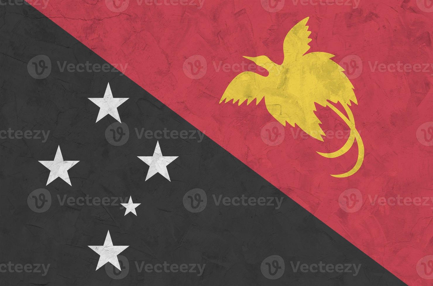 bandeira de papua nova guiné retratada em cores brilhantes de tinta na parede de reboco em relevo antigo. banner texturizado em fundo áspero foto