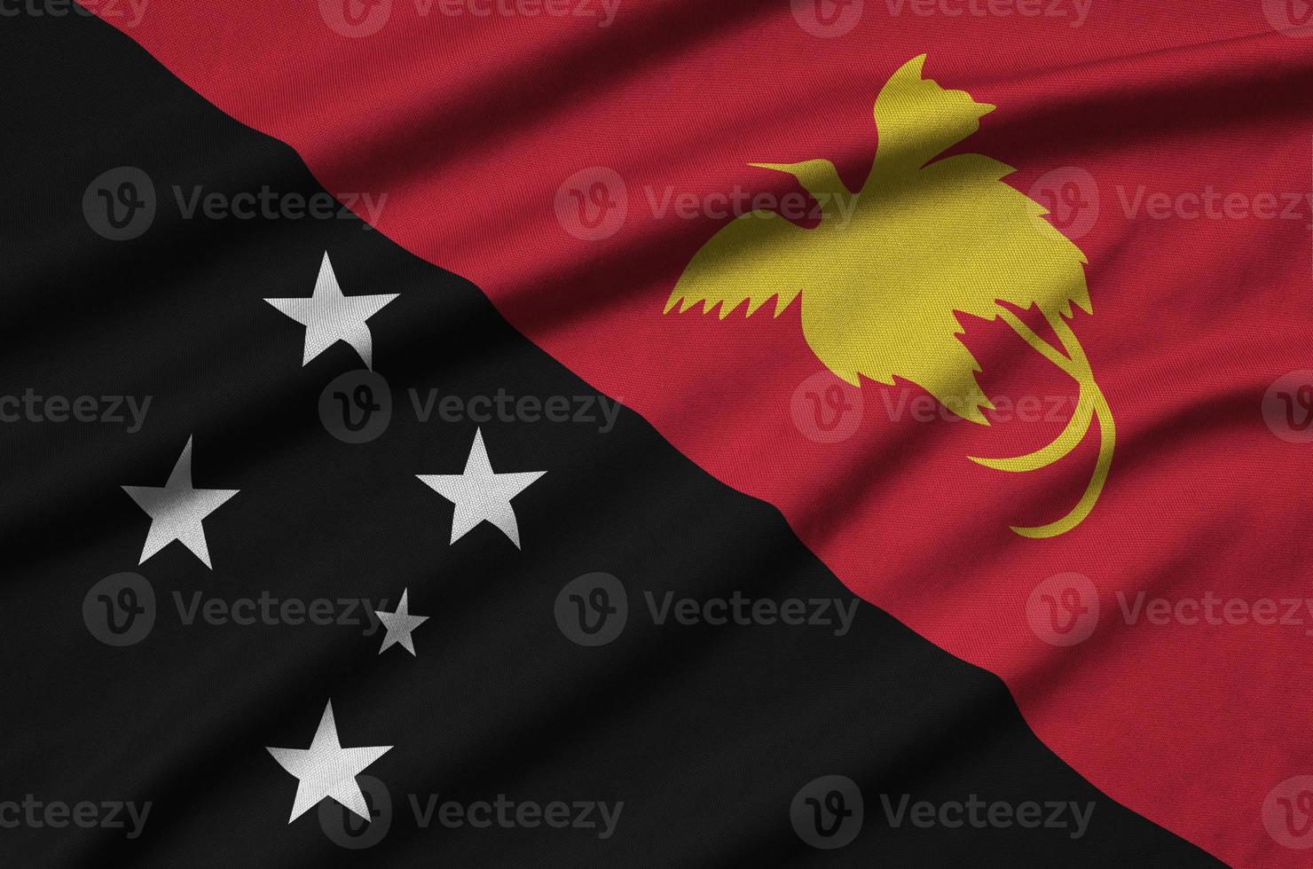 a bandeira de papua nova guiné é retratada em um tecido esportivo com muitas dobras. bandeira da equipe esportiva foto