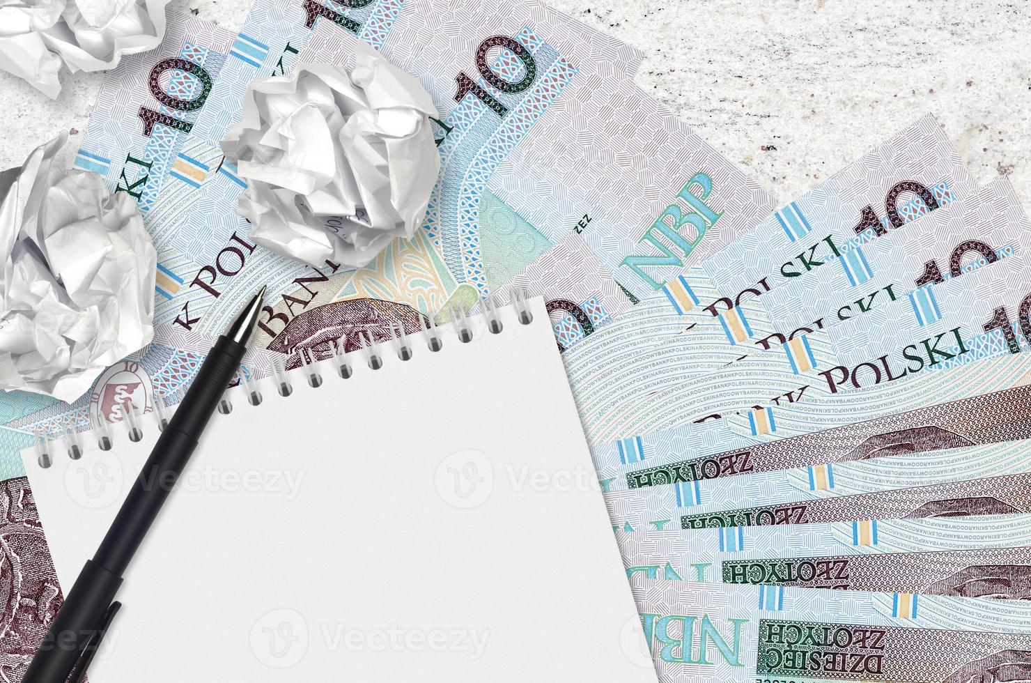 10 contas de zloty polonês e bolas de papel amassado com bloco de notas em branco. ideias ruins ou menos do conceito de inspiração. procurando ideias para investimento foto