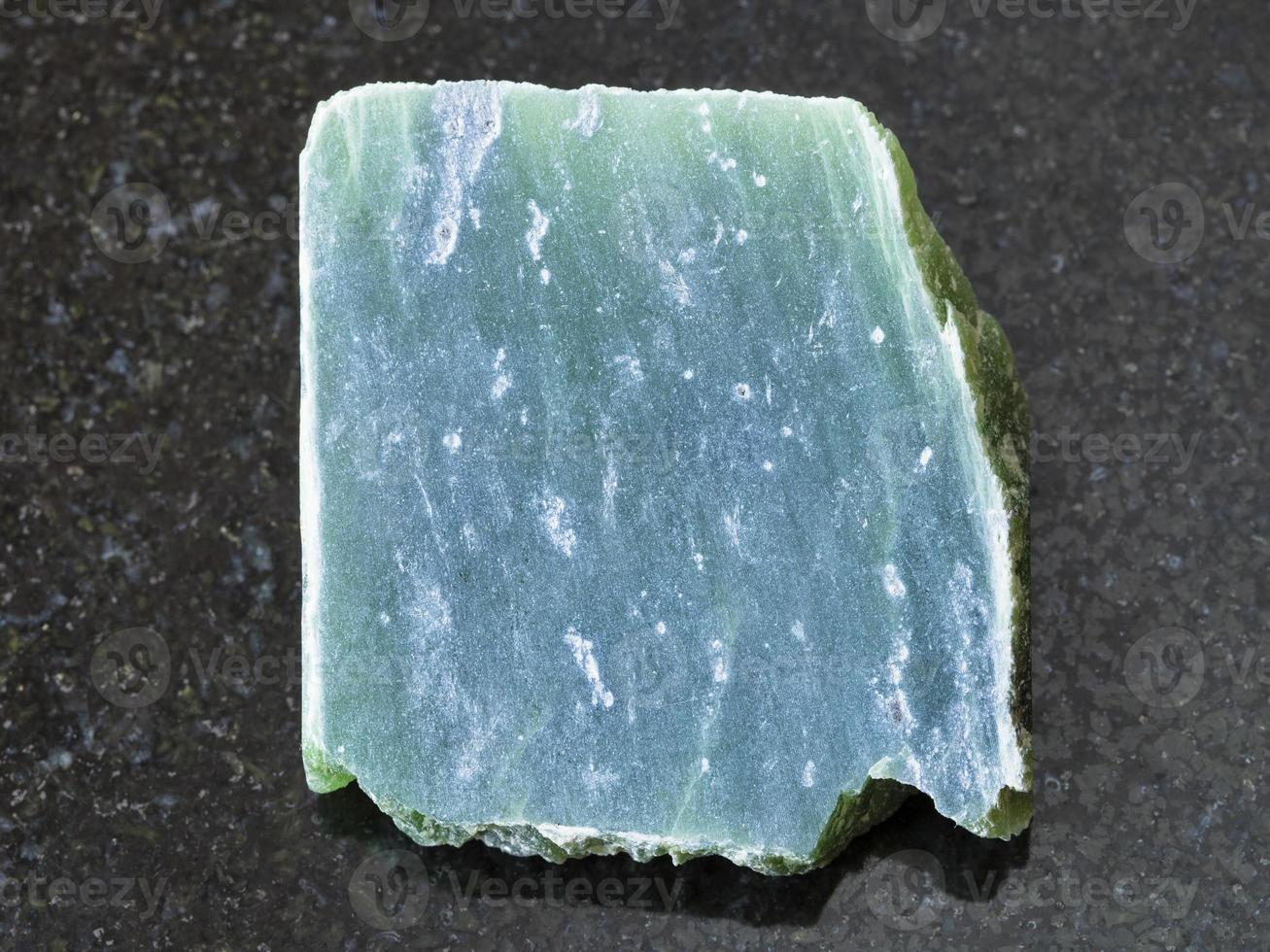 laje de pedra de nefrite cru em fundo escuro foto