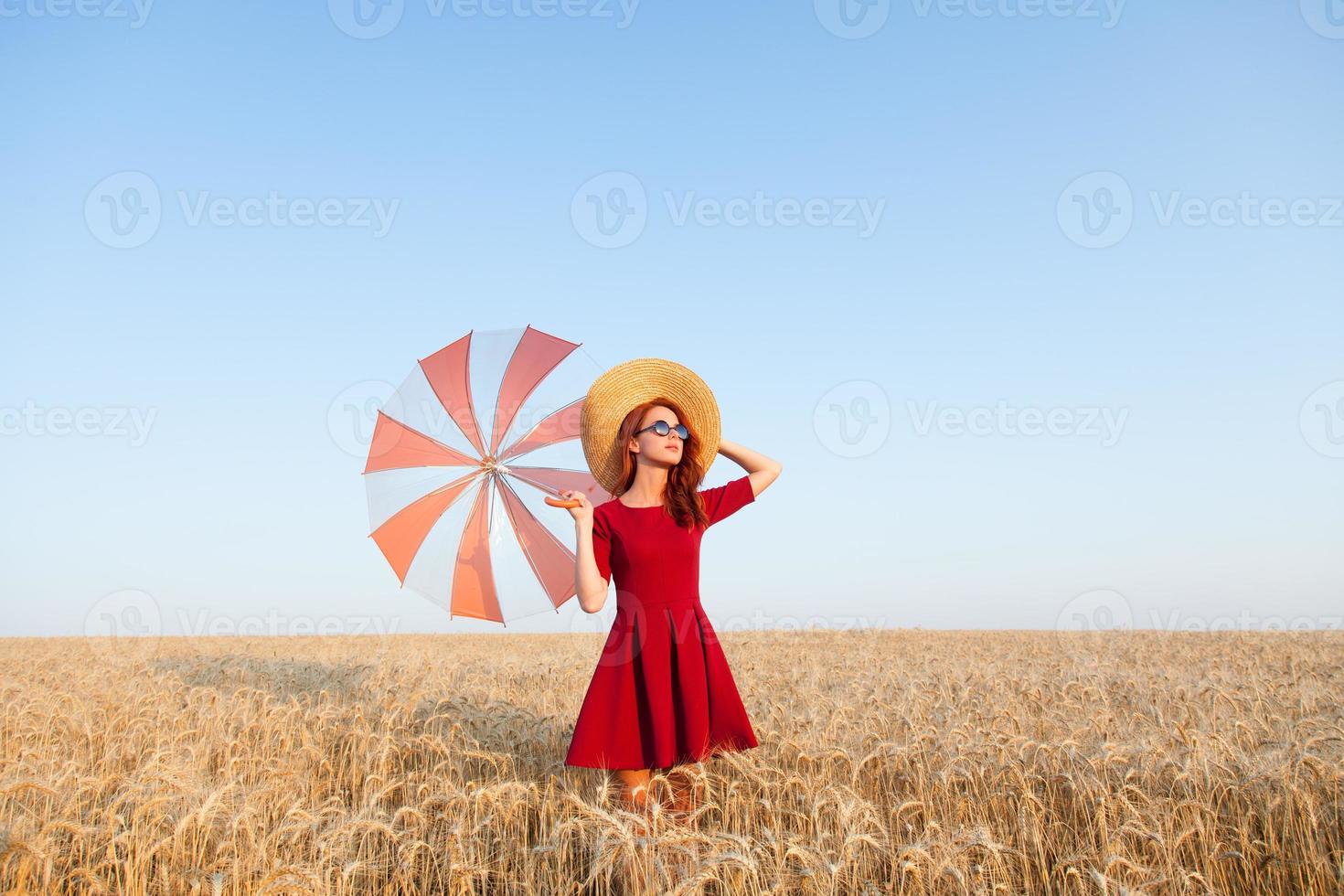 garota de vestido vermelho com guarda-chuva e chapéu foto