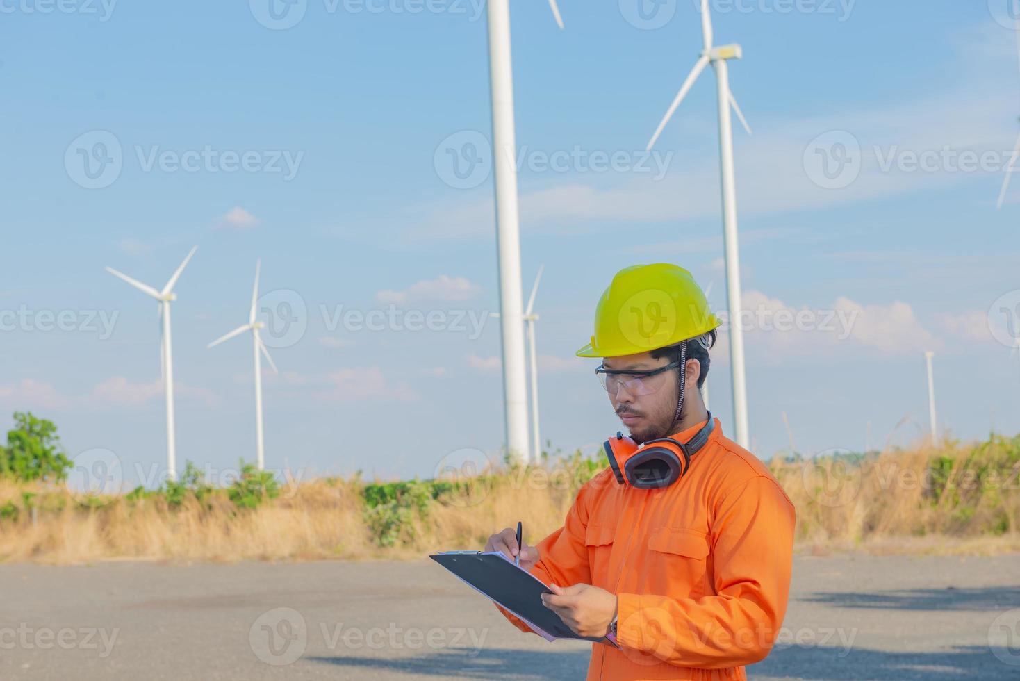 silhueta de engenheiro de homem trabalhando e segurando o relatório na estação de gerador de energia de turbina eólica na montanha, tailândia foto
