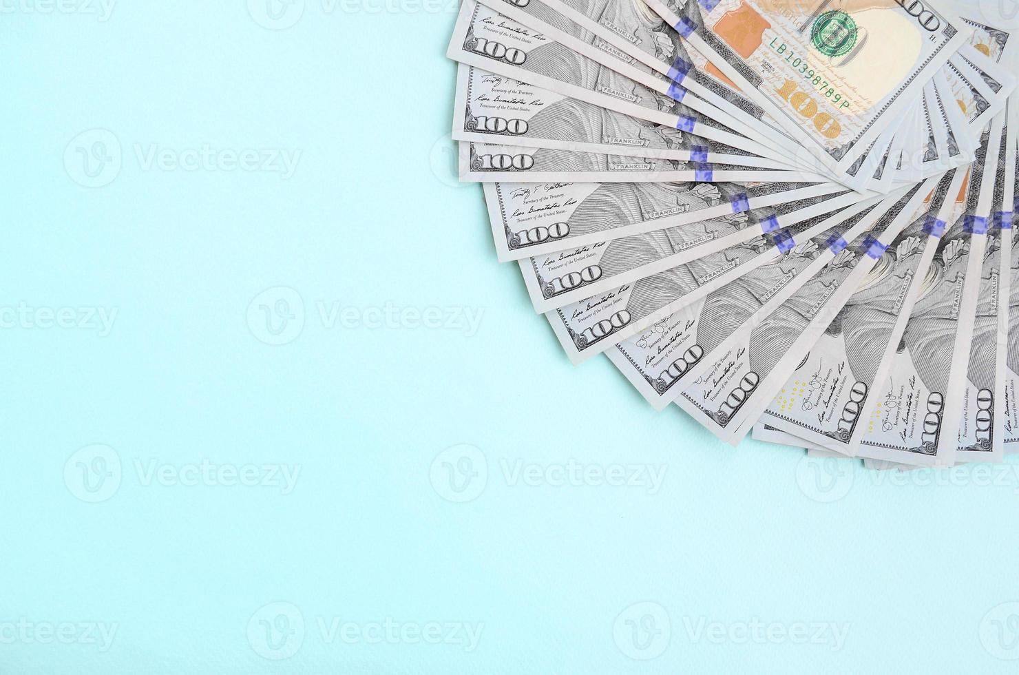 fã de notas de um dólar americano de um novo design encontra-se em um fundo azul claro foto