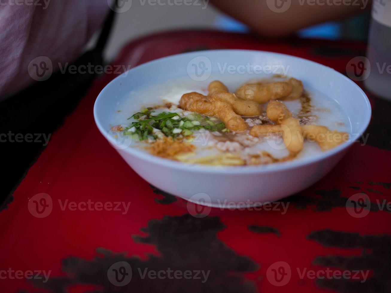 mingau chinês com ovo em um intestino com rosquinha chinesa. conjunto de café da manhã conceito foto