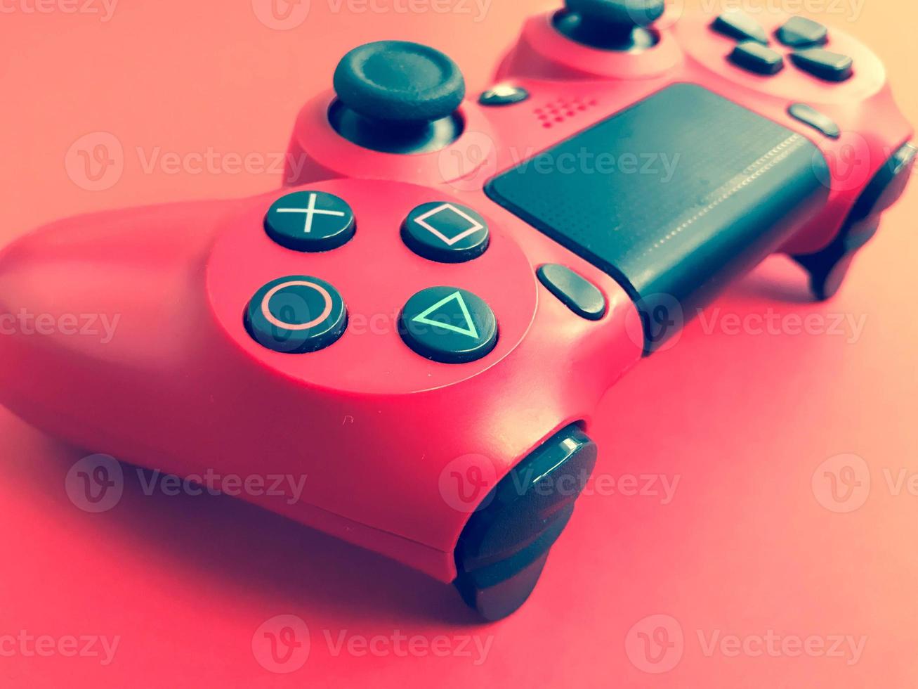 lindo novo joystick de jogo moderno digital vermelho para videogame de computador gamepad em um fundo vermelho foto