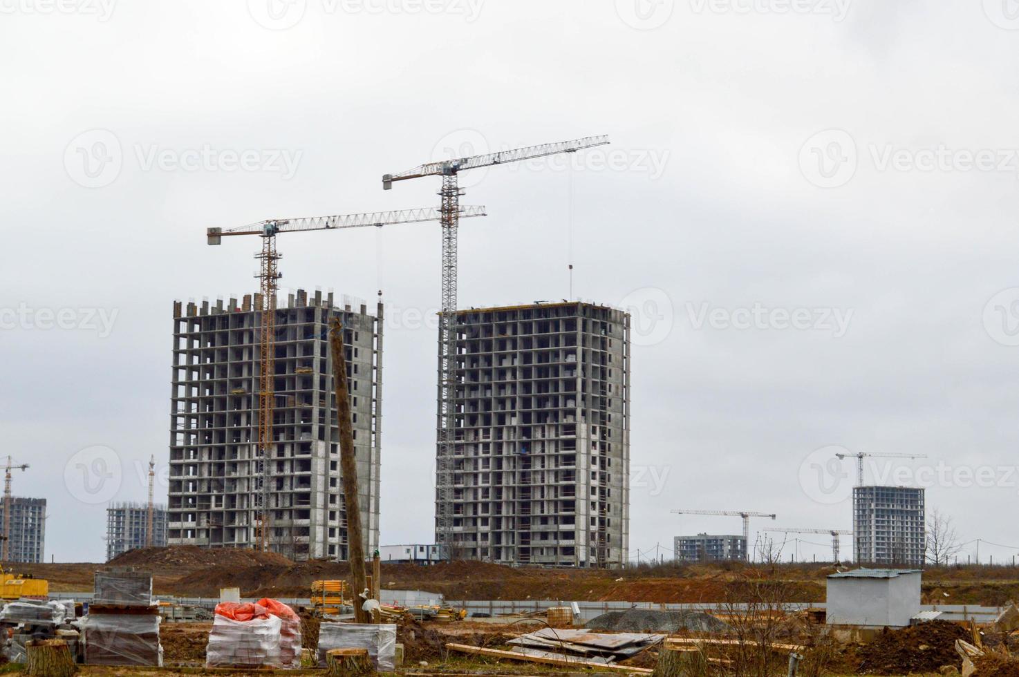 construção de um novo microdistrito com casas altas, novos prédios com infraestrutura desenvolvida com a ajuda de grandes guindastes industriais e equipamentos profissionais de construção em uma grande cidade foto