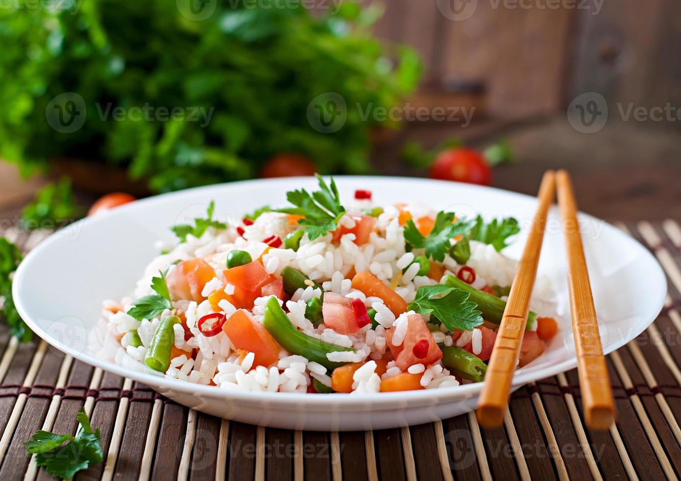 apetitoso arroz saudável com legumes em chapa branca sobre um fundo de madeira. foto