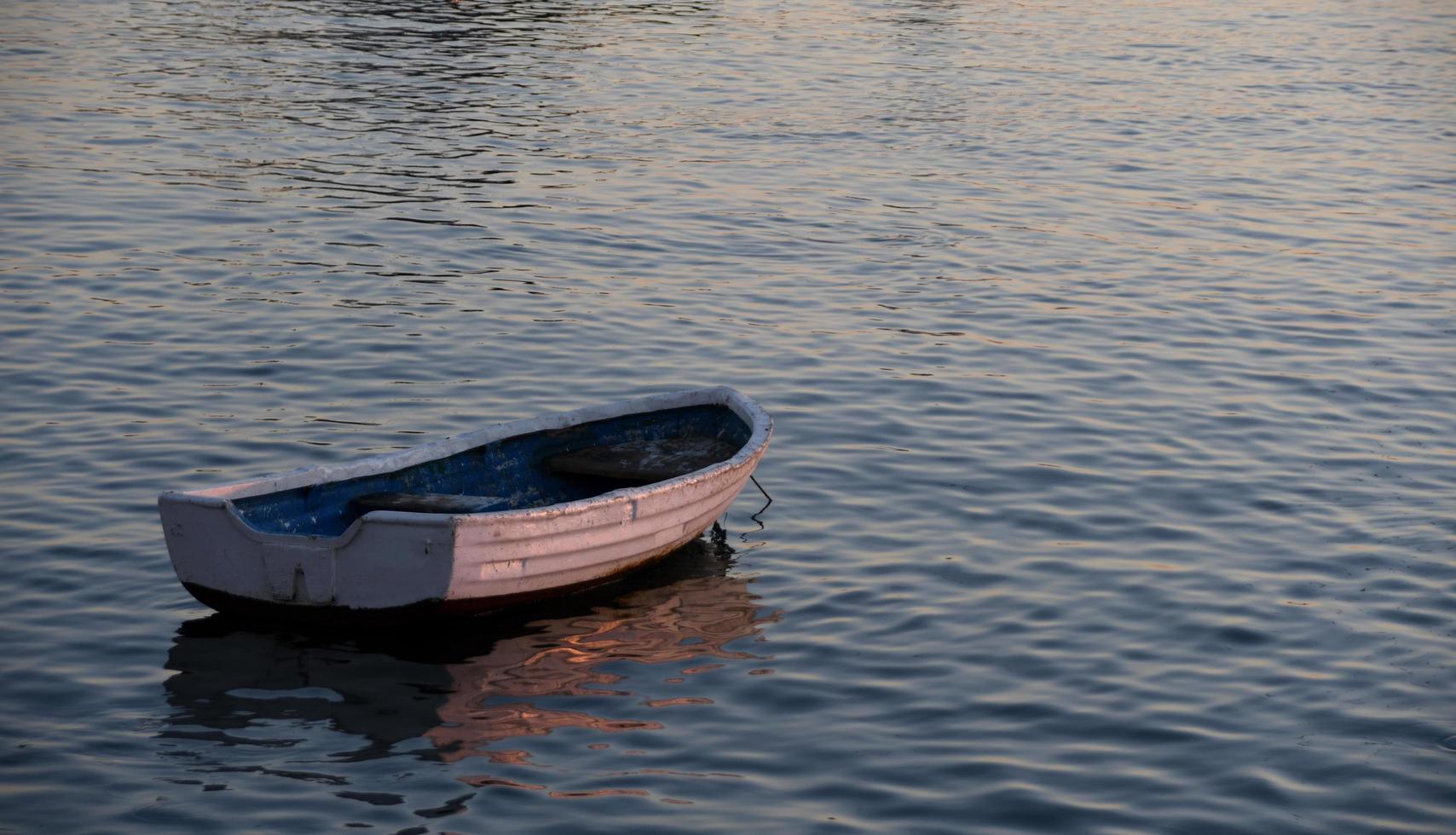 pequeno barco na praia ao pôr do sol foto