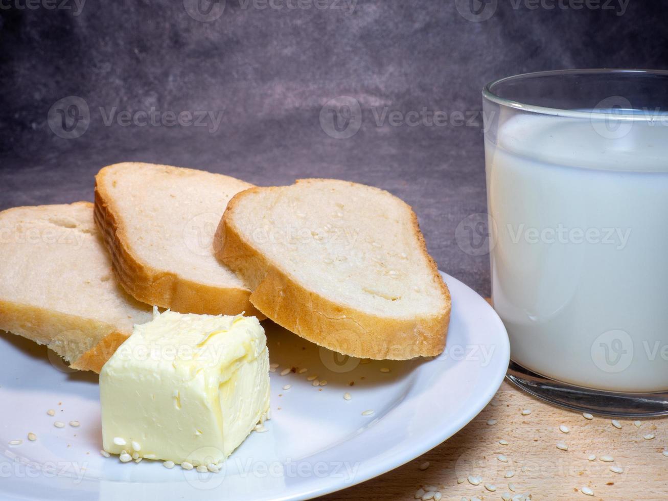 pedaços de centeio e pão branco com um copo de leite em um prato. café da manhã saudável. produtos de confeitaria foto