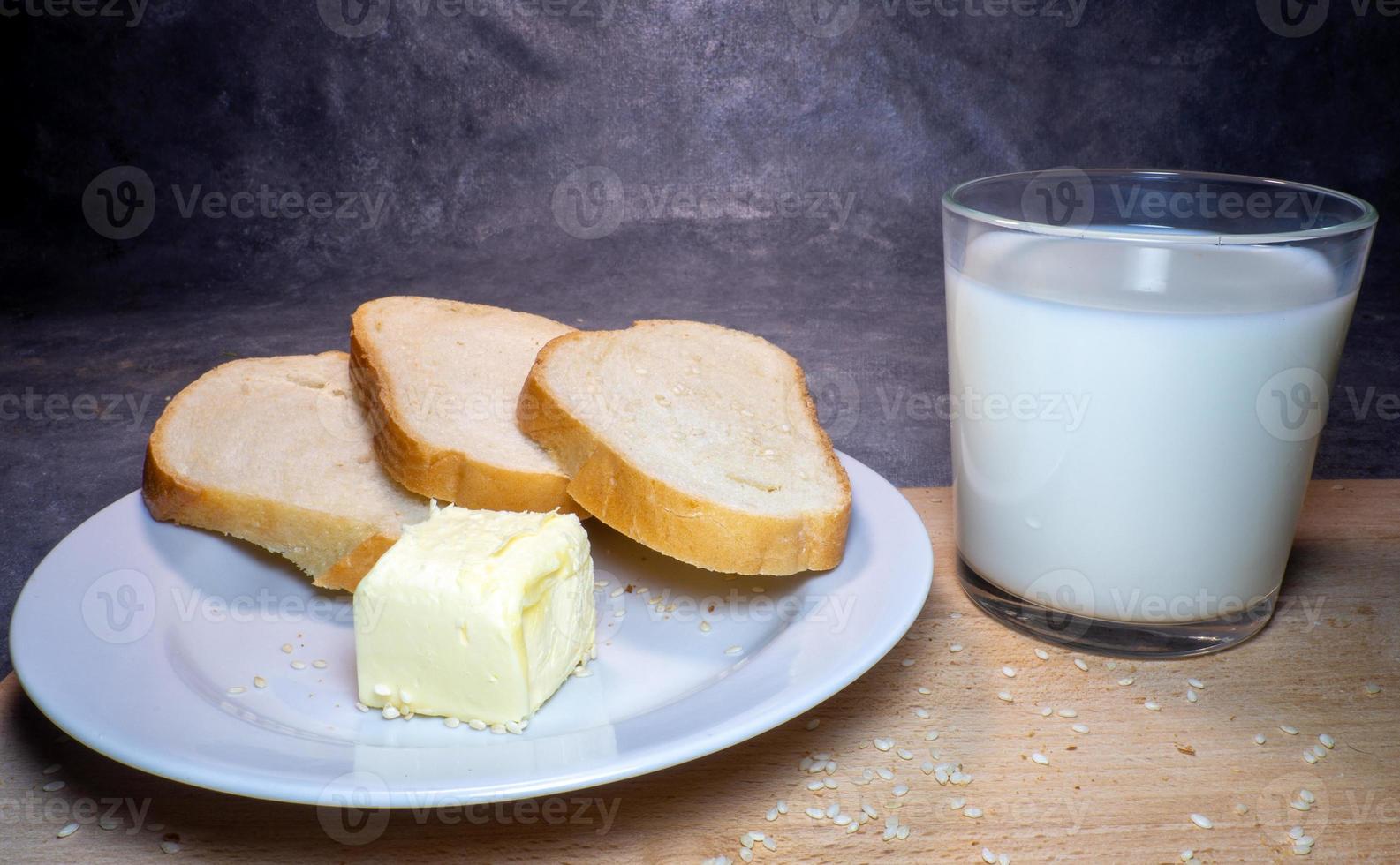 pedaços de centeio e pão branco com um copo de leite em um prato. café da manhã saudável. produtos de confeitaria foto