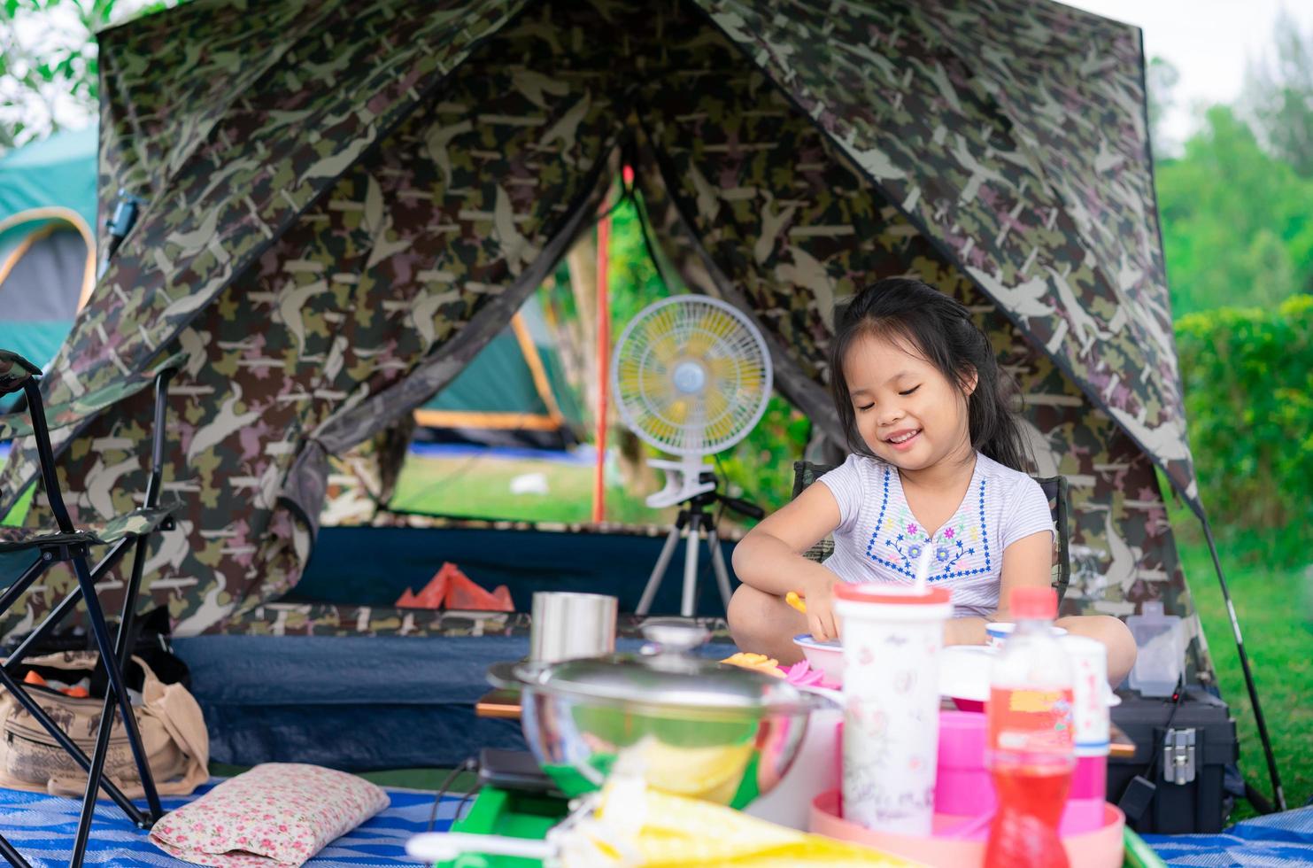 menina sentada na frente da tenda foto