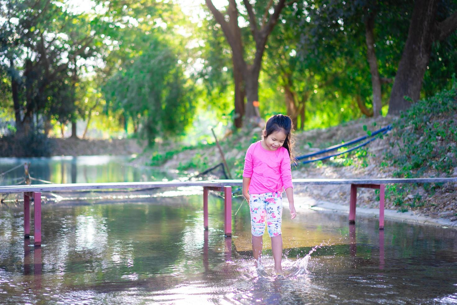 garotinha asiática brincando na água foto