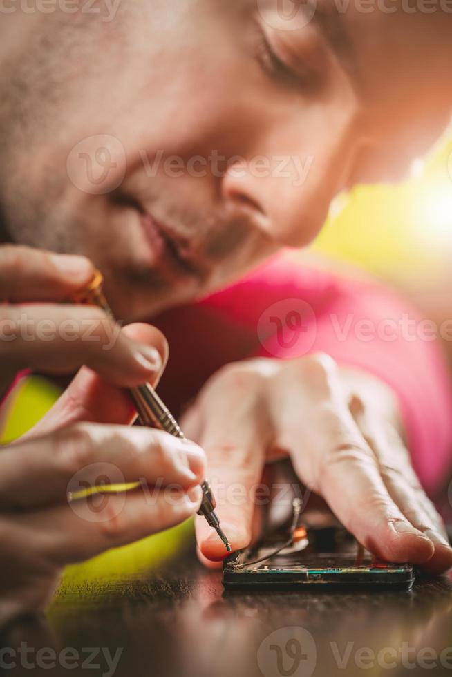 homem consertando um celular foto