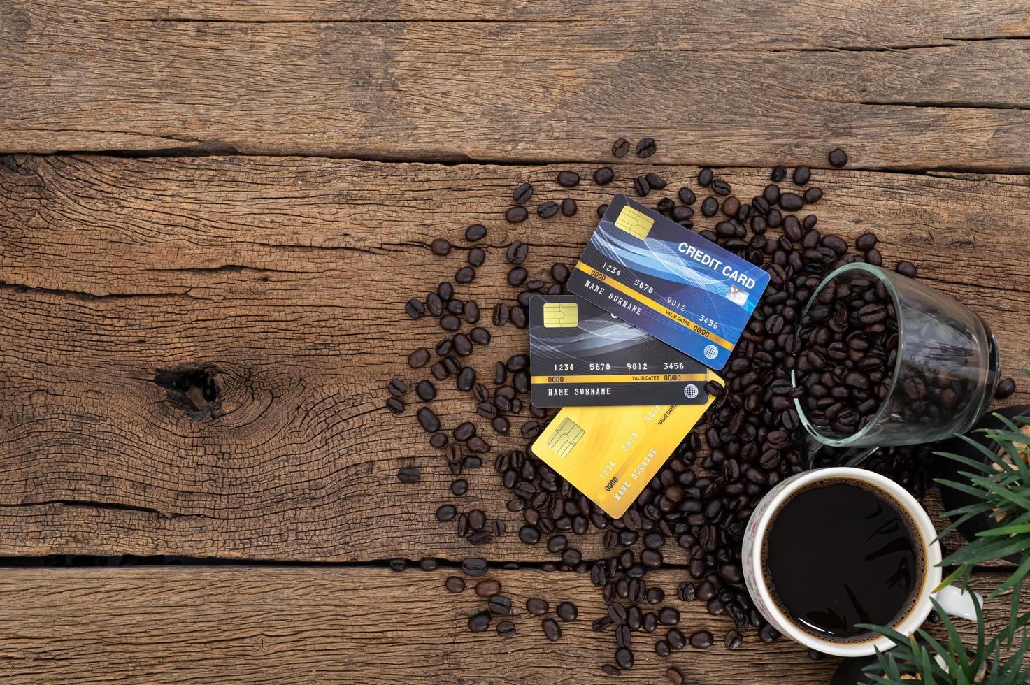 cartões de crédito e grãos de café na mesa foto