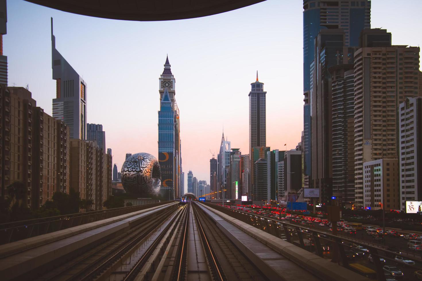 dubai, emirados árabes unidos, 2022 - metro chega à paragem de metro na cidade de dubai com fundo panorâmico de edifícios modernos foto