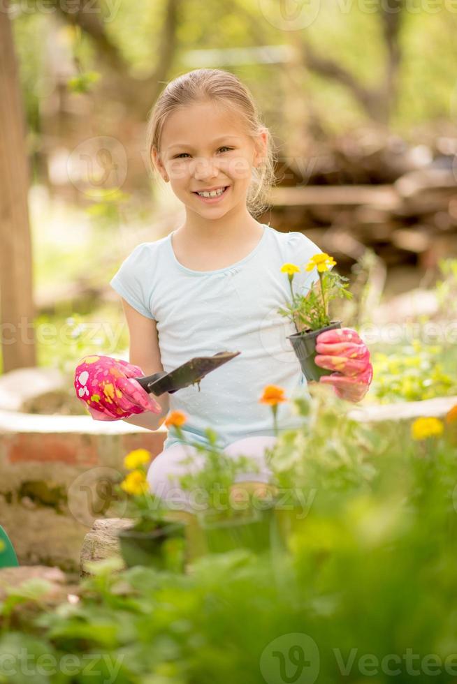 menina bonitinha plantando flores foto